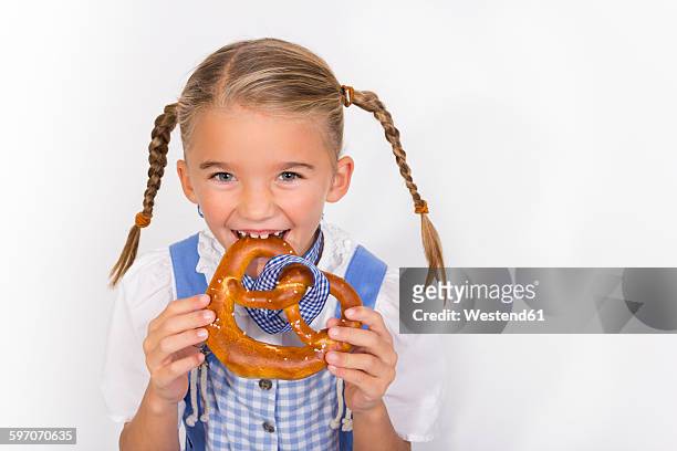portrait of little girl eating pretzel - brezel stock-fotos und bilder