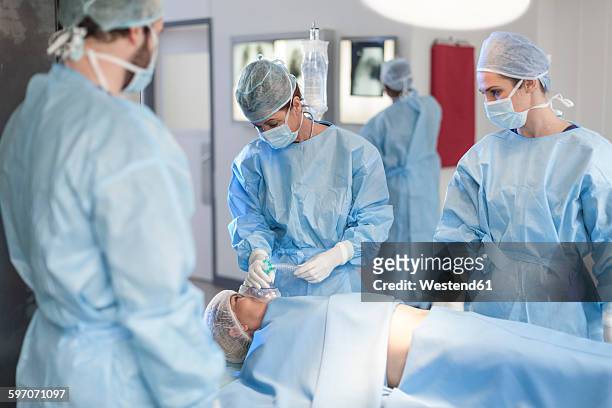 surgical team anesthetizing patient - respiratory machine stock-fotos und bilder
