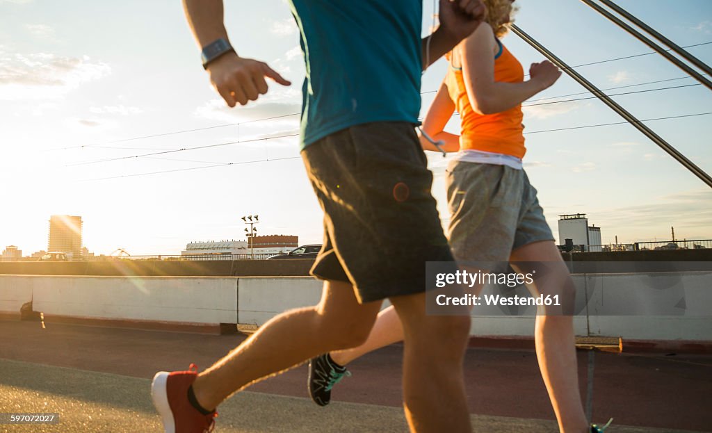 Young couple running on a bridge