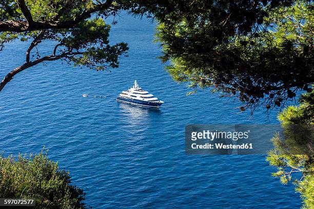 italy, capri, luxury yacht anchoring at steep coast - super yacht stock pictures, royalty-free photos & images