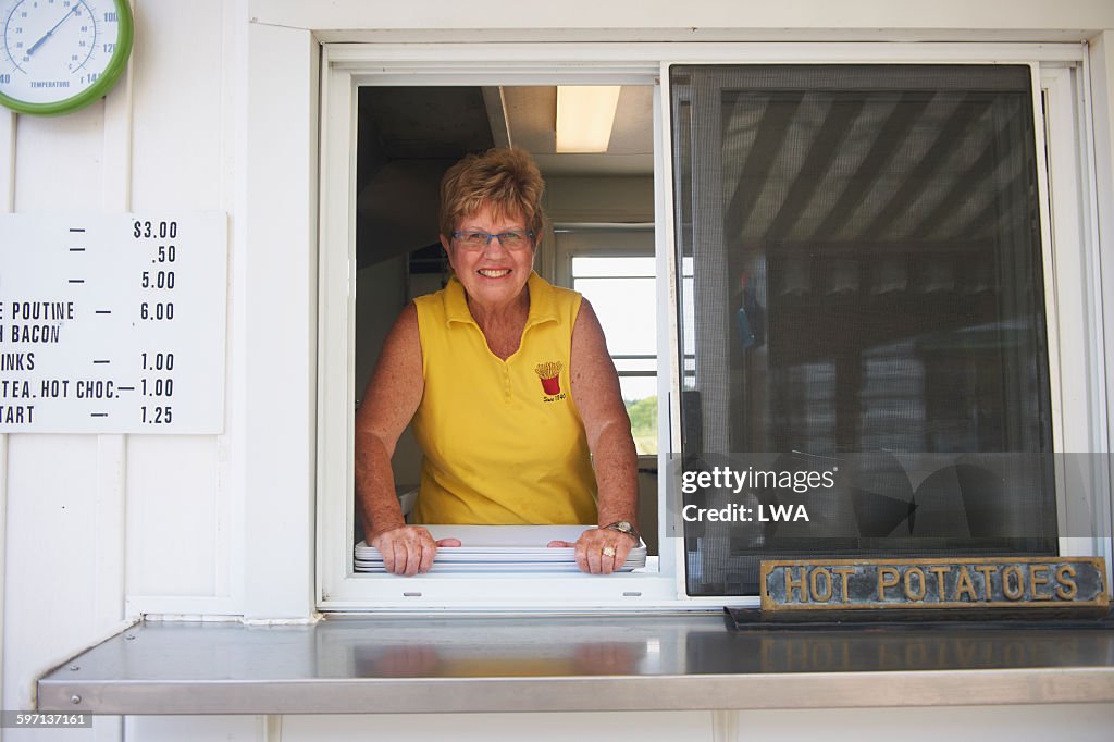 Mature woman in food truck window