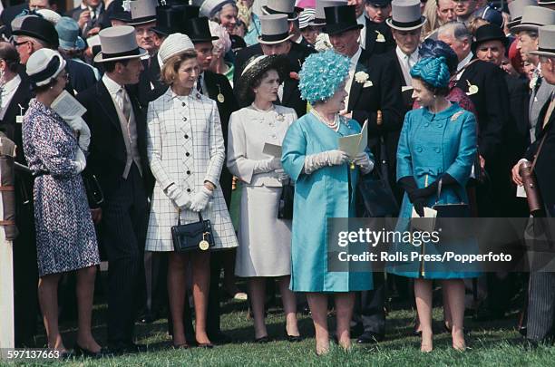 Queen Elizabeth II, on far right wearing a light blue coat and hat talks with her mother Queen Elizabeth The Queen Mother, wearing a turquoise summer...