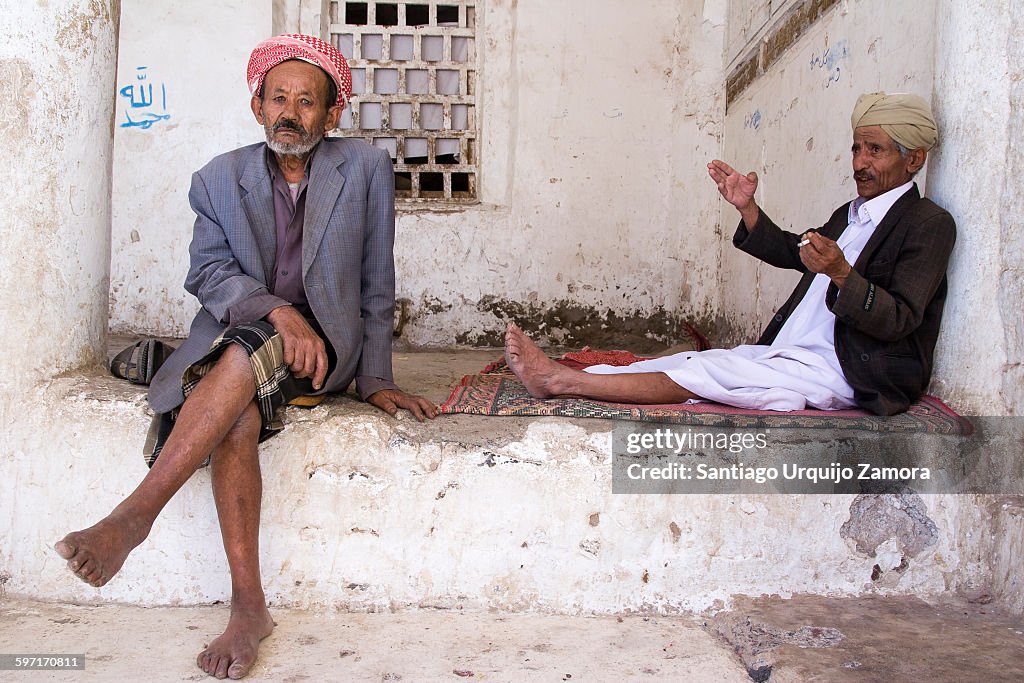 Two Muslim men resting inside a mosque