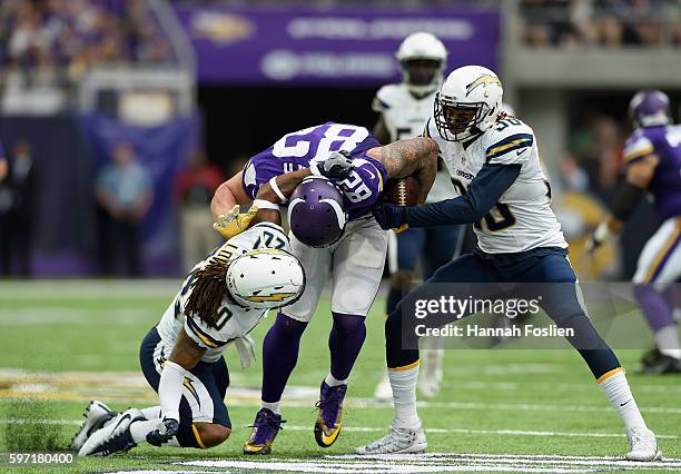 Dwight Lowery of the San Diego Chargers tackles Kyle Rudolph of the Minnesota Vikings as teammate Dexter McCoil forces a fumble during the second...