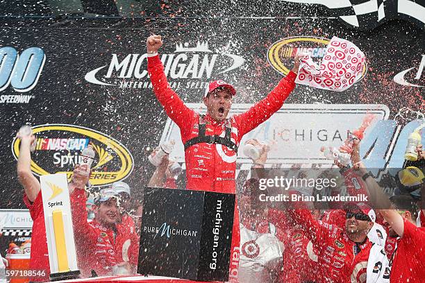 Kyle Larson, driver of the Target Chevrolet, celebrates in victory lane after winning the NASCAR Sprint Cup Series Pure Michigan 400 at Michigan...