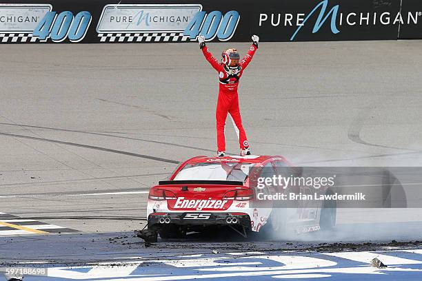 Kyle Larson, driver of the Target Chevrolet, celebrates after winning the NASCAR Sprint Cup Series Pure Michigan 400 at Michigan International...