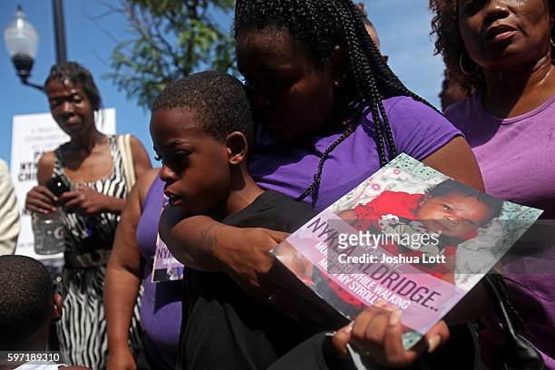 Raven Roberts puts her arm around Sincere Simmons as they attend a prayer vigil for Simmons' mother Nykea Aldridge outside Willie Mae Morris...