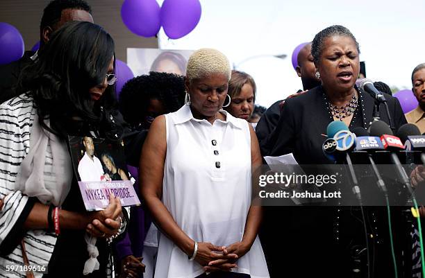 Diann Aldridge, center, the mother of Nykea Aldridge bows her head during a vigil for her daughter as her sister Jolinda Wade, right, leads a prayer...