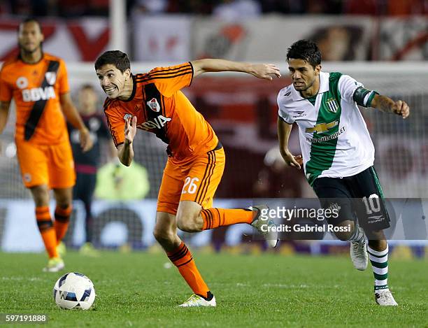 Ignacio Fernandez of River Plate drives the ball past Walter Erviti of Banfield during a match between River Plate and Banfield as part of first...
