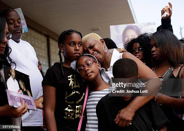 Diann Aldridge, center, the mother of Nykea Aldridge get emotional as she holds her grandchildren, Summer Aldridge , Shave Lenord and Sincere Simmons...