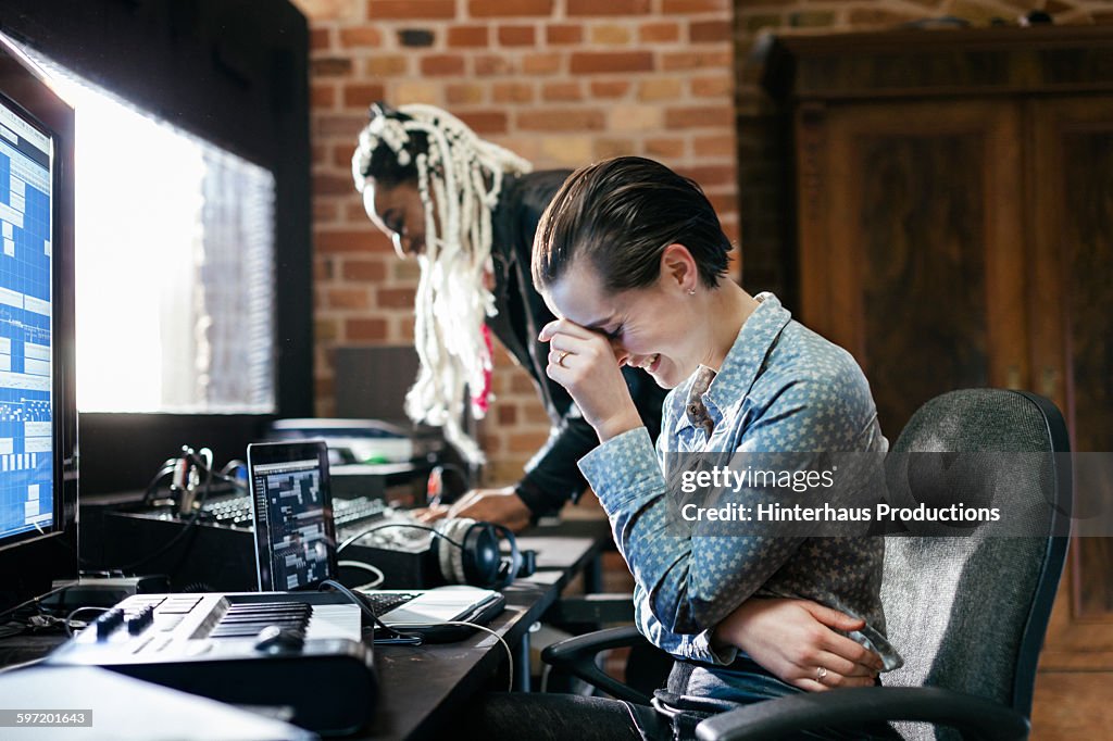 Sound engineer laughing in record studio