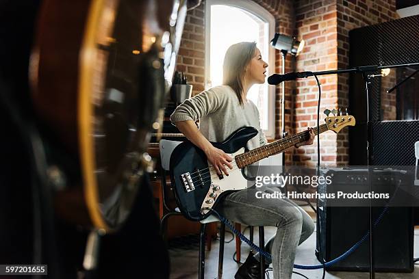 female singer playing guitar and performing a song - saiteninstrument spielen stock-fotos und bilder