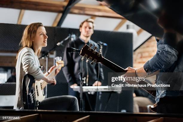 young band recording music in a studio - music band stock-fotos und bilder