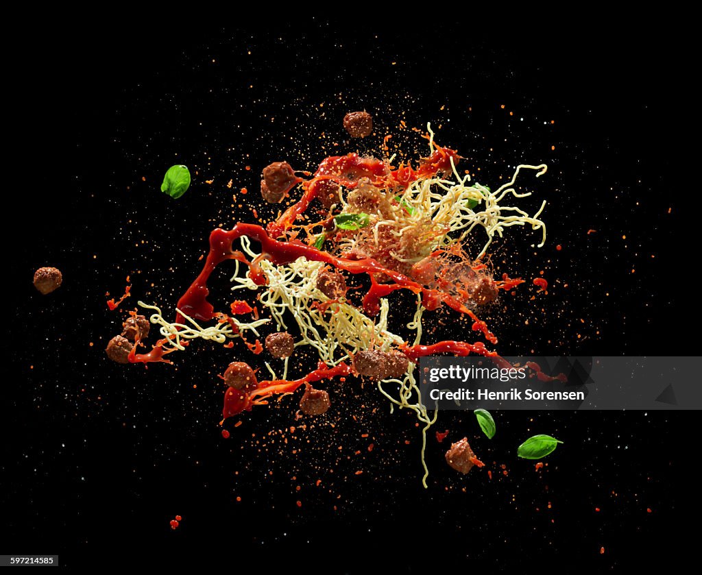 Spaghetti and meatballs splashing in air