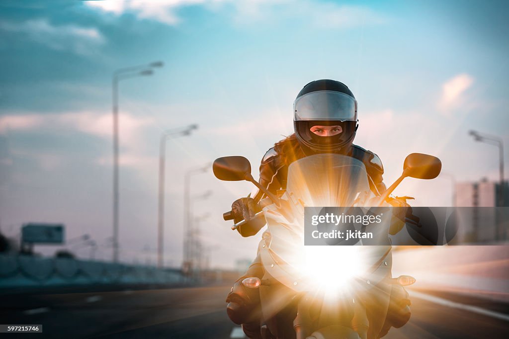 Frau fährt auf Motorrad auf morgendliche Autobahn
