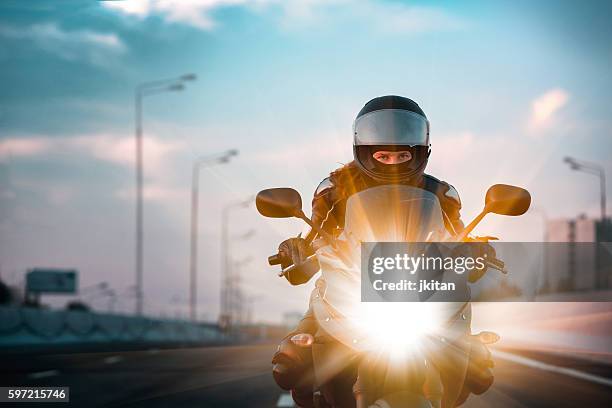 mujer conduce en una motocicleta en una carretera de la mañana - montar un vehículo fotografías e imágenes de stock