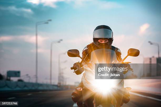 woman drives on a motorcycle on a morning highway - corrida de motos imagens e fotografias de stock