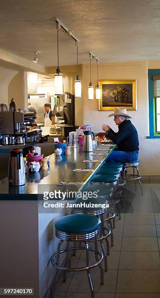 santa fe nm: cowboy mangia da solo al bancone del pranzo vecchio stile - man eating at diner counter foto e immagini stock