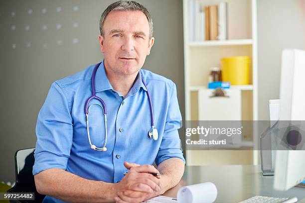 gp in his office - doctor looking at camera stock pictures, royalty-free photos & images