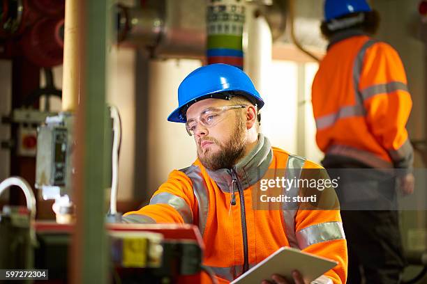 engineer's inspecting boiler room machinery - boiler engineer stockfoto's en -beelden