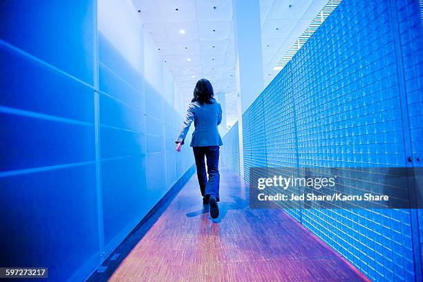 japanese businesswoman walking in hallway - office action foto e immagini stock