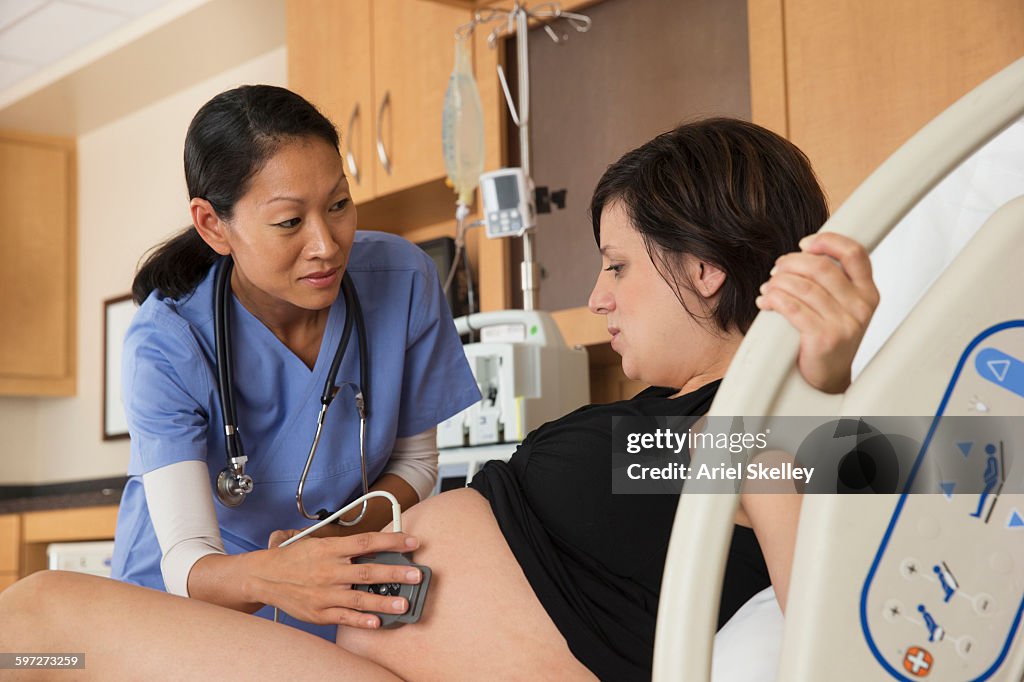 Doctor examining belly of pregnant woman