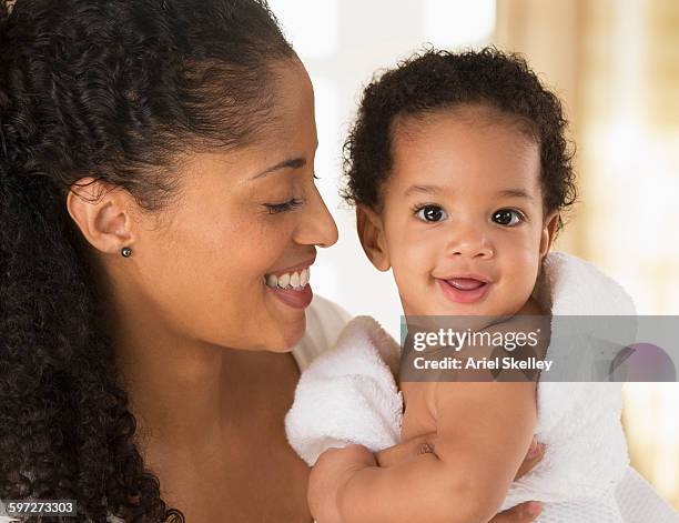 mixed race mother drying baby son in towel - envuelto en una toalla fotografías e imágenes de stock