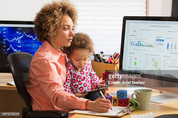 black businesswoman with daughter working at home - children looking graph stock pictures, royalty-free photos & images