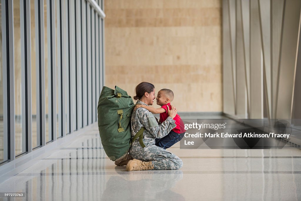 African American soldier hugging son in airport