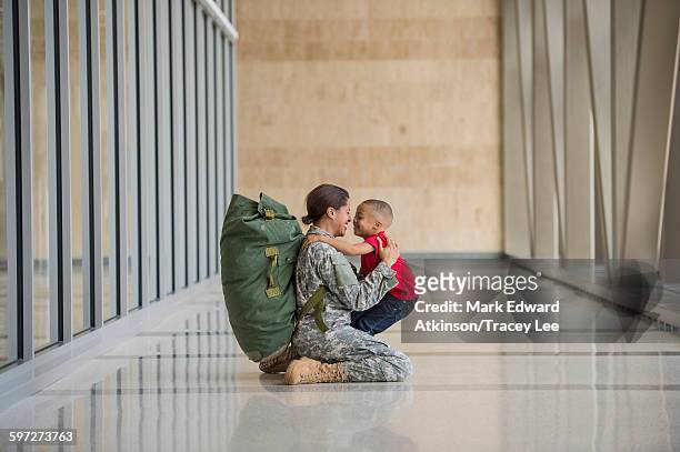 african american soldier hugging son in airport - armed forces stock pictures, royalty-free photos & images