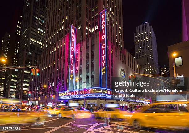 yellow cabs and radio city music hall at night, new york, usa - cultura americana stock-fotos und bilder