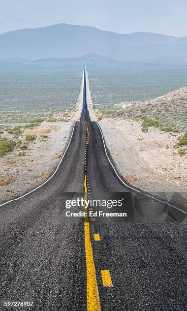 long, straight road going off in the distance - linea gialla foto e immagini stock