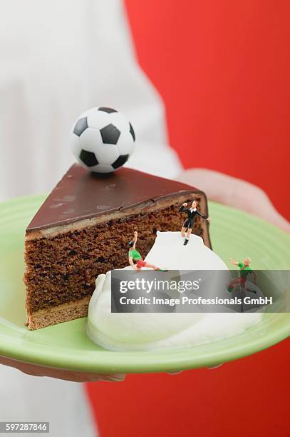 person holding piece of sacher torte with cream & football - calcium scoring stock pictures, royalty-free photos & images