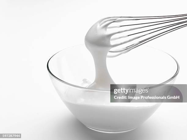 whipped cream in bowl with whisk - bianco d'uovo foto e immagini stock