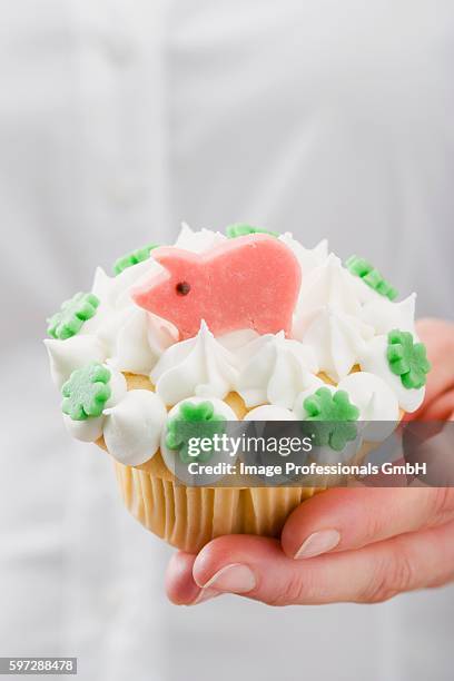 hand holding cupcake with marzipan pig - marzipan stock pictures, royalty-free photos & images