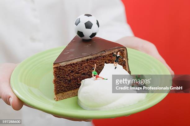 person holding piece of sacher torte with cream & football - calcium scoring stock pictures, royalty-free photos & images