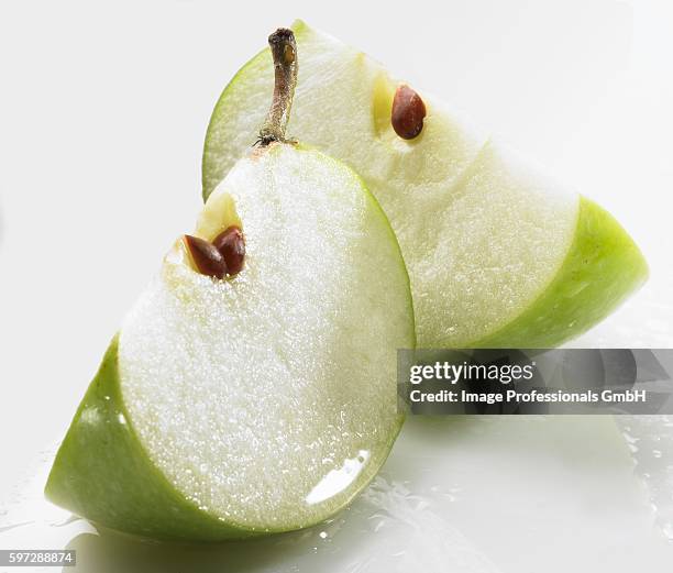 two wedges of green apple - green apple slices stock pictures, royalty-free photos & images