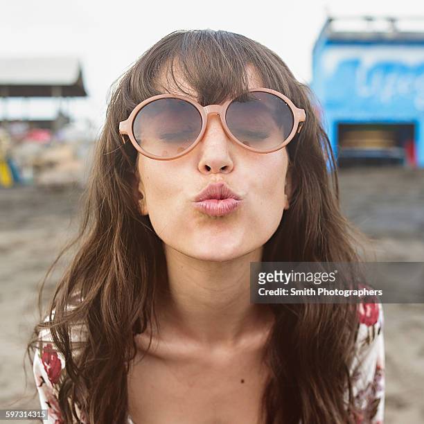 caucasian woman in sunglasses puckering to kiss at beach - kiss lips - fotografias e filmes do acervo