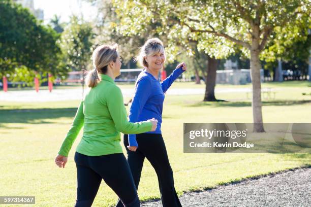 caucasian women walking in park - mature women walking stock pictures, royalty-free photos & images