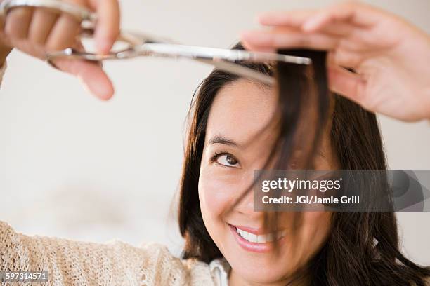 chinese woman cutting her bangs - bangs stock pictures, royalty-free photos & images