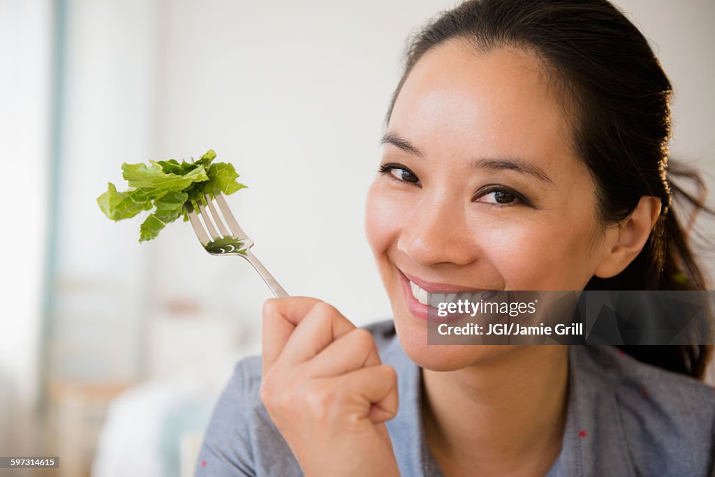 Chinese woman eating salad