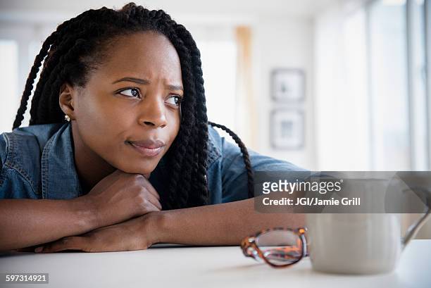 anxious black woman resting chin on hands - angry black woman stock pictures, royalty-free photos & images