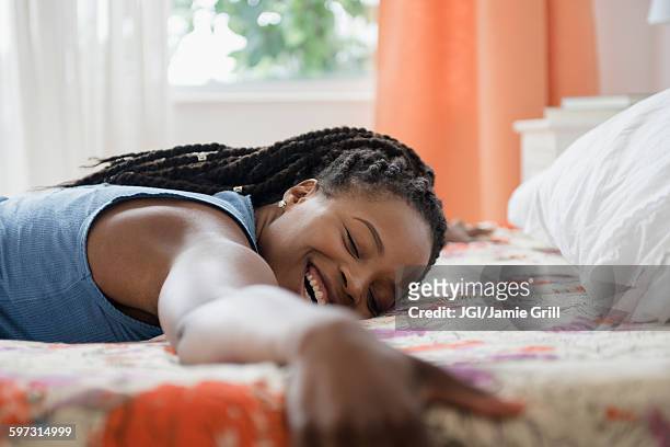 black woman laying on bed - relief foto e immagini stock