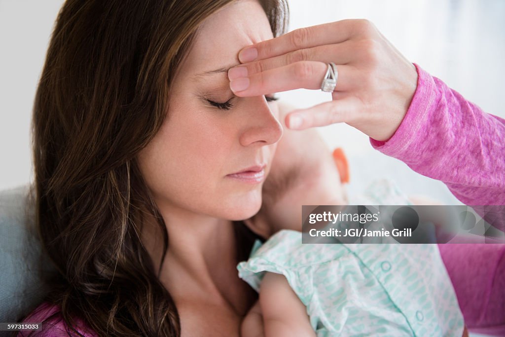 Stressed mother pinching her forehead