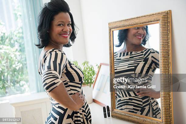 black woman smiling near mirror - black mirror imagens e fotografias de stock