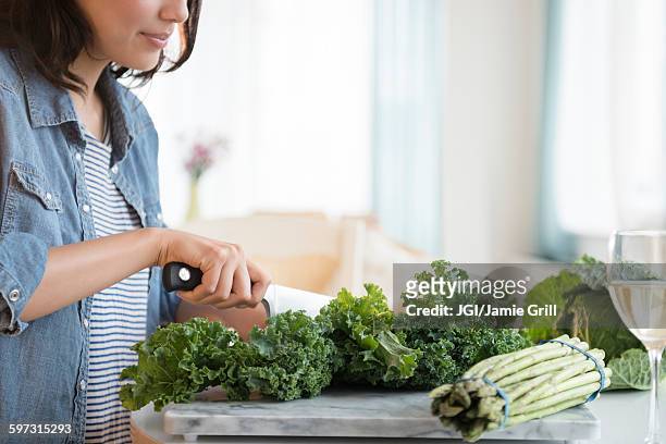 hispanic woman chopping salad greens - leaf vegetable stock pictures, royalty-free photos & images