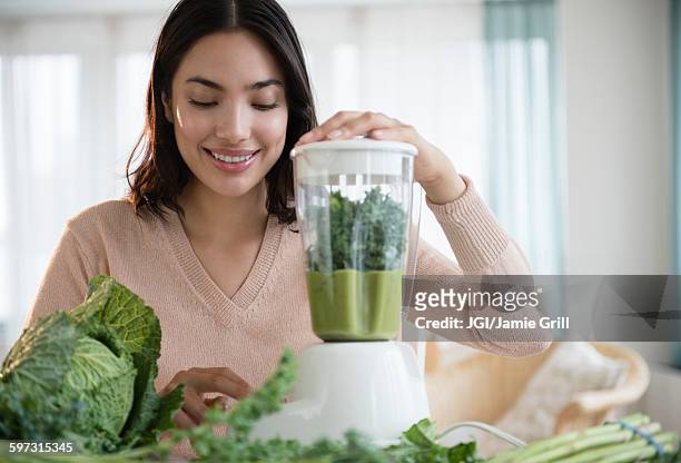 hispanic woman blending healthy smoothie - cabbage stock-fotos und bilder