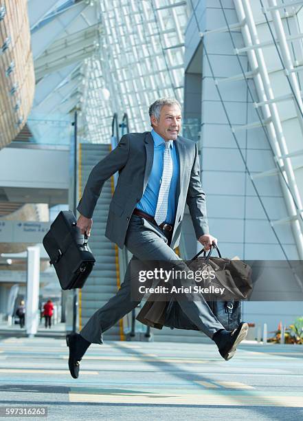 mixed race businessman running in airport - running up an escalator stock pictures, royalty-free photos & images