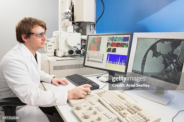 caucasian scientist using computer in laboratory - microscopio elettronico a scansione foto e immagini stock