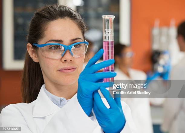 hispanic scientist measuring liquid in laboratory - measuring cylinder stock pictures, royalty-free photos & images